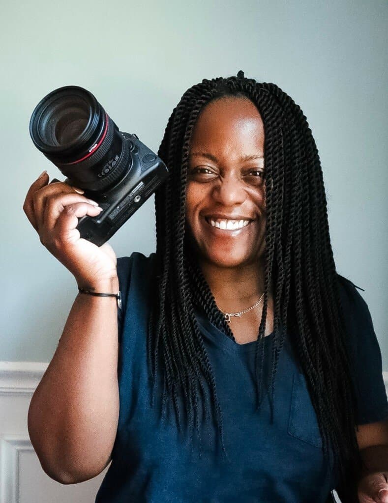 smiling holding my canon 6D as a part to show a piece of my travel photography gear