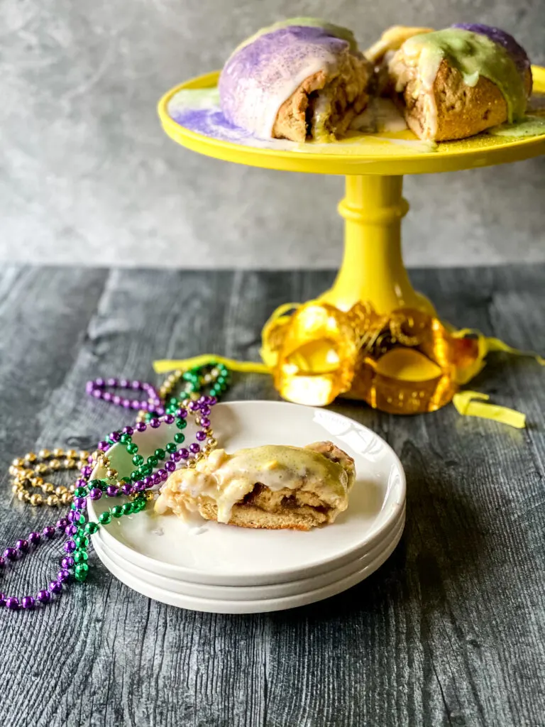 king cake on a plate with mardi gras beads